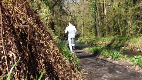 vista trasera de un hombre corriendo por un sendero forestal
