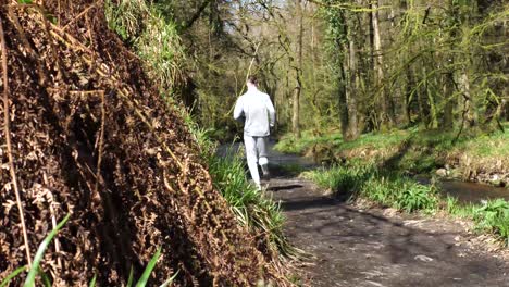 back view of a man running along a forest path