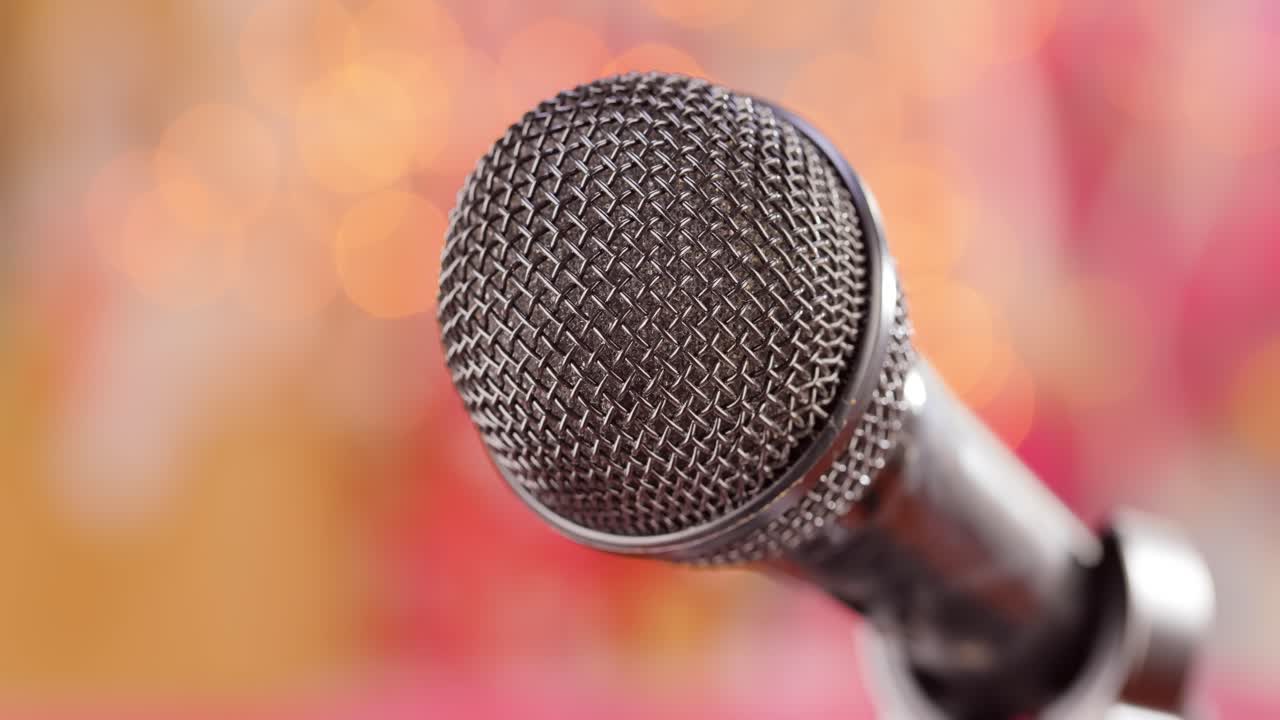 Microphone on stage against a blurry light ,blurry background.