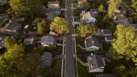 aerial over nice suburban street with middle class houses at golden hour