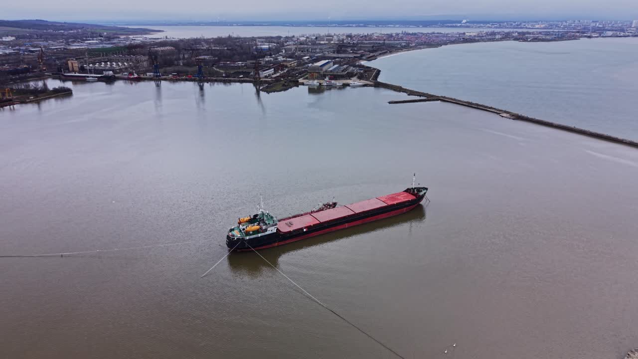 Cargo ship moves through the water near the shipyard in the harbor