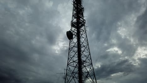 Bedrohlicher-Zeitraffer-Eines-Silhouettierten-Fernmeldeturms-Mit-Wolken-Im-Hintergrund