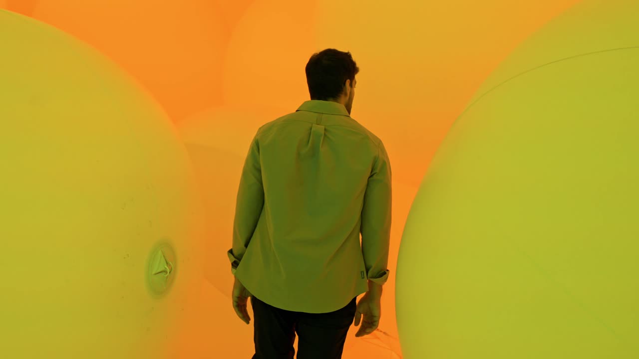 A mesmerizing scene of a man walking through the enchanting light installations at TeamLab Planets in Tokyo.