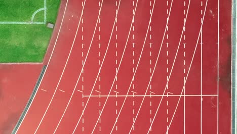 running track at the stadium, color is orange brick, high angle view by drone.