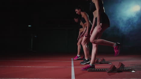 female athletes warming up at running track before a race. in slow motion