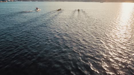 cinematic drone flight following rowers on lake union during golden sunset in seattle city, washington