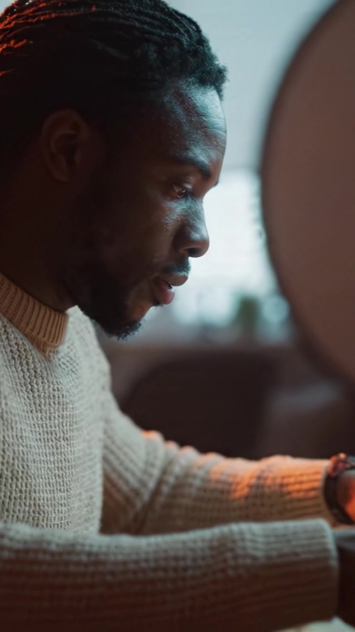 A focused individual immersed in paperwork, highlighting concentration and determination while engaged in important tasks at a workspace bathed in soft light.