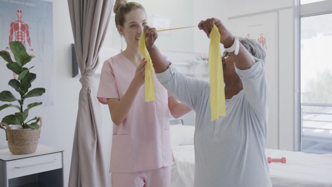 행복한 다양한 여성 물리치료사와 노인 여성 환자가 운동 밴드, 느린 동작을 사용합니다.