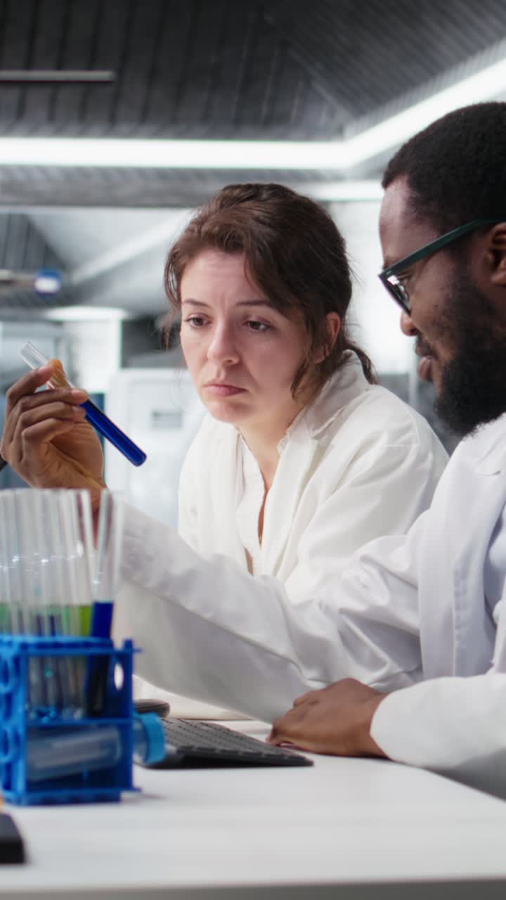 Vertical video Team of lab chemical engineers inspecting clarity of chemical solution