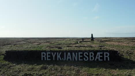 signo de reykjanesbã¦r en la cima de una colina en islandia en un día soleado, aérea