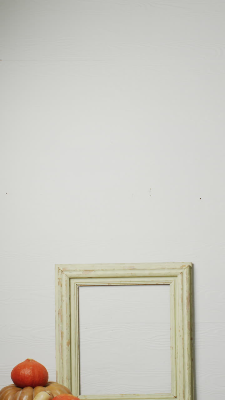 video vertical de calabazas con hojas de otoño y marco con espacio de copia en fondo blanco