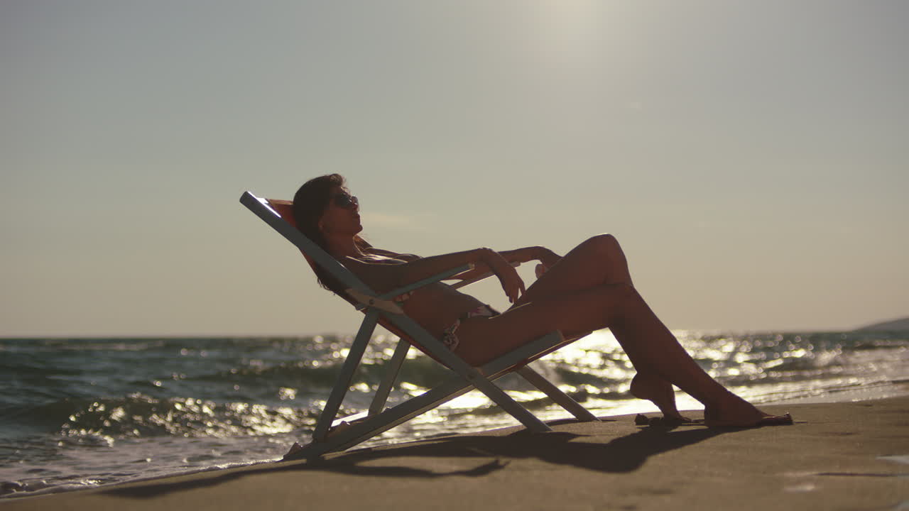 Woman Relaxing on Beach Chair at Sunset