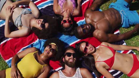 grupo diverso de amigos tomando el sol juntos y sonriendo en un día soleado