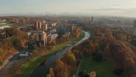 aerial drone shot of a czech big city ostrava with alongside river buldings, cars, roads, apartments, power plant and towers during autumn fall day