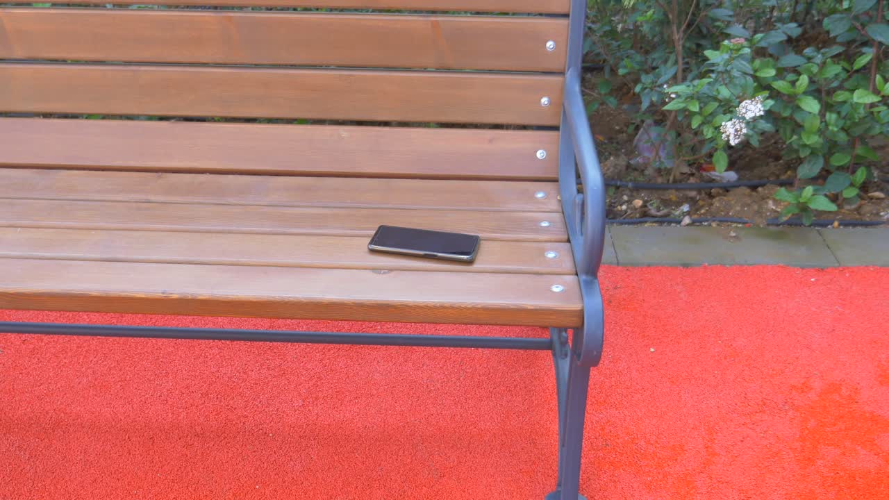 teléfono móvil perdido en un banco del parque