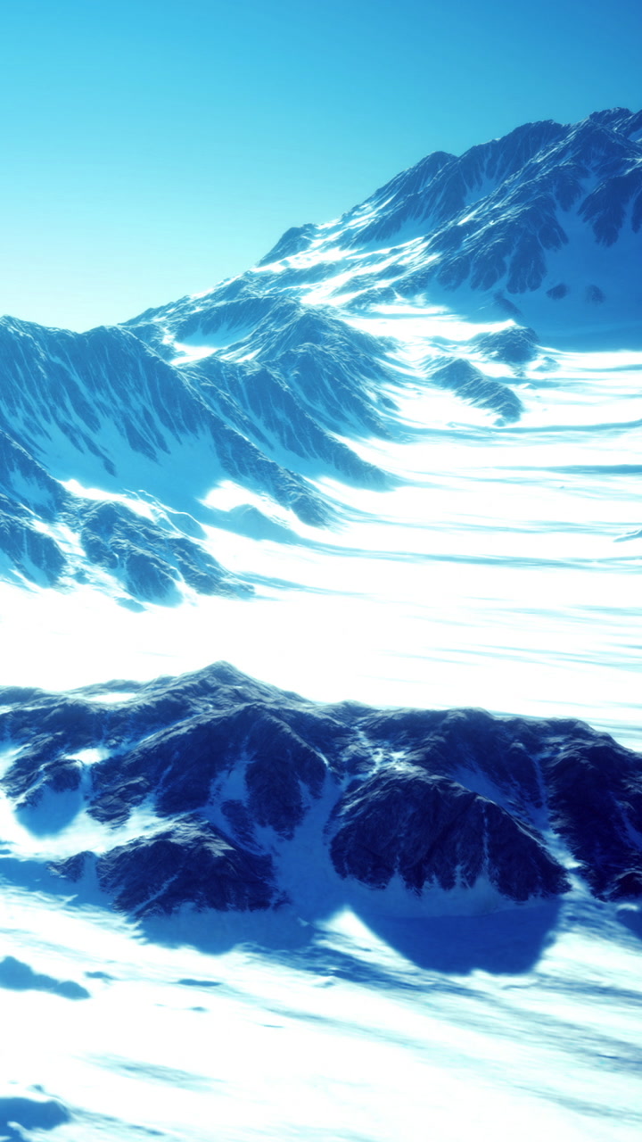 Snowy mountain landscape under a clear blue sky at sunrise