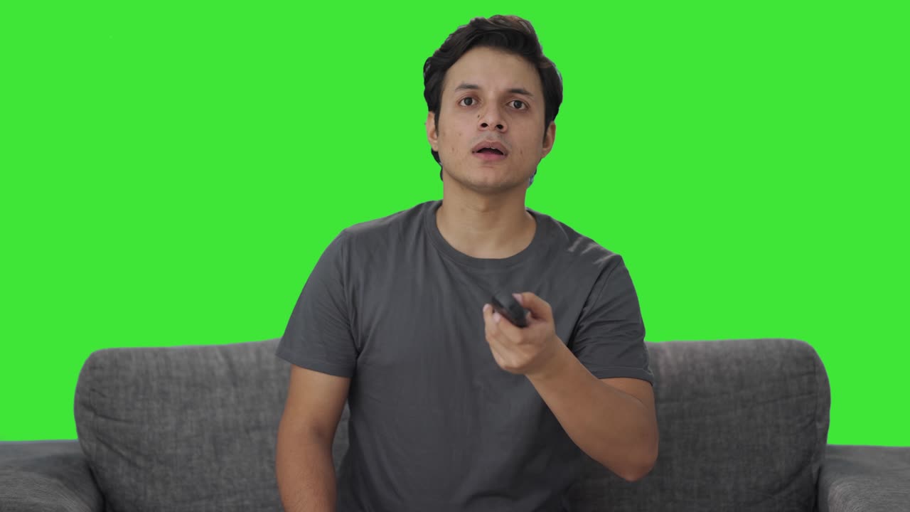 Indisk mand ser en chokerende nyhed på tv Green screen