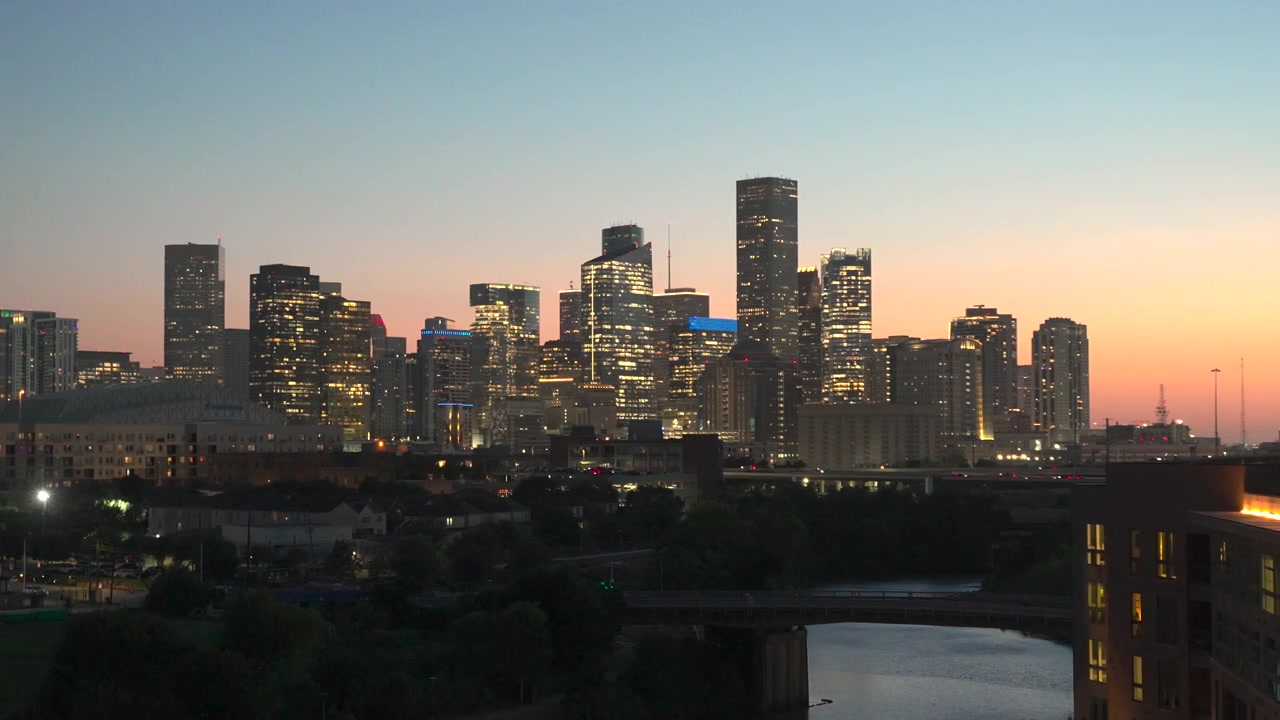 Horizonte del centro de Houston iluminado en la hora azul con vistas a Buffalo Bayou, mostrando modernos rascacielos y el perfil de la ciudad al anochecer en Houston, Texas, EE. UU.