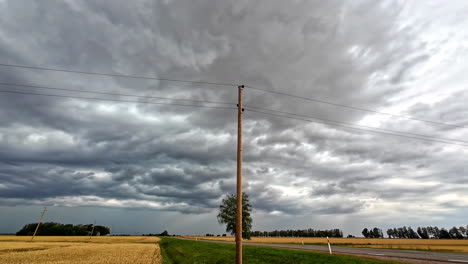 old electricity line near road with grey clouds above, time lapse