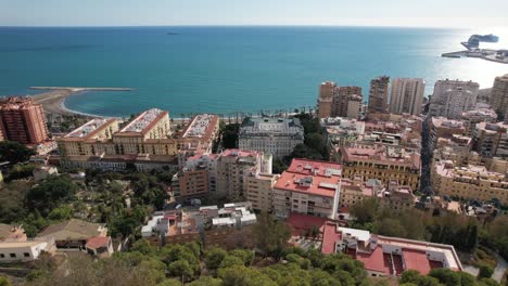 City-seascape-Fuengirola-drone-reveal-with-buildings-and-blue-summer-sky-horizon