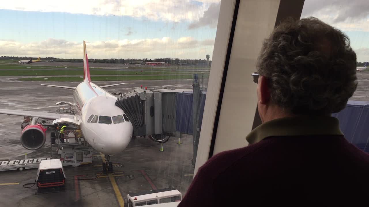 hombre de edad observando avión en el aeropuerto de españa