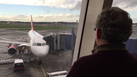 aged man watching airplane in the airport of spain