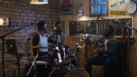 three musicians recording music in a home studio