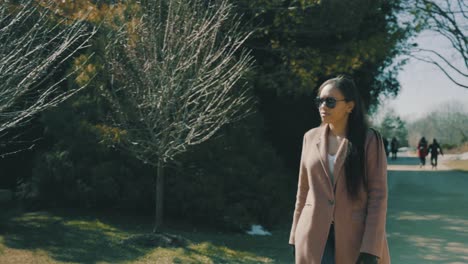 a beautiful woman walks down a dirt road into a park on a cold winter day