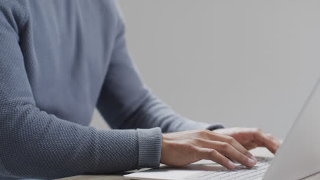 Midsection-of-biracial-businessman-using-laptop-at-desk,-copy-space