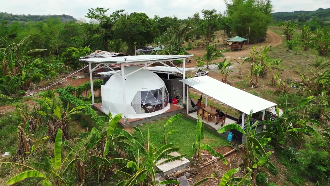 Dronepanorama af en bjergindkvartering i Tanay, Rizal med en kuppelstruktur, floddal og udsigt over Sierra Madre-bjergkædens foden i Luzon