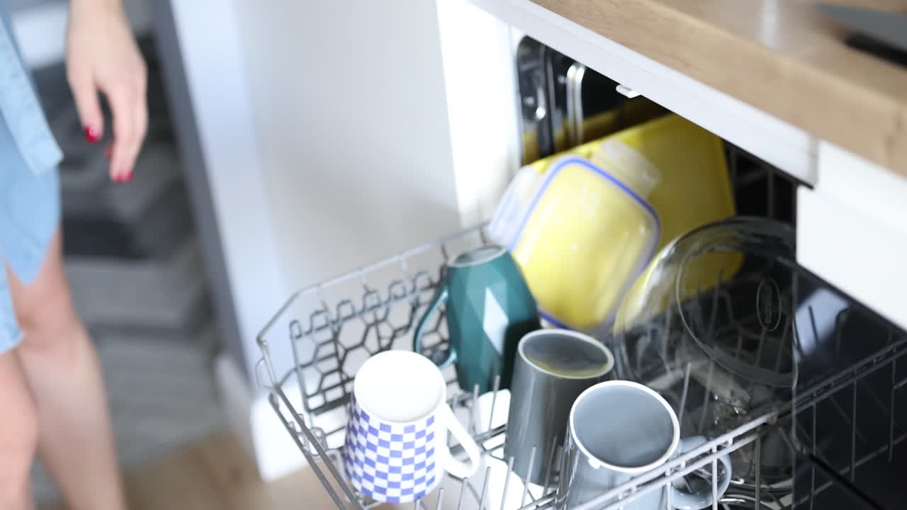 Person Loading and Unloading Dishes from a Dishwasher