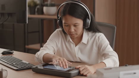 young woman using a digital braille display