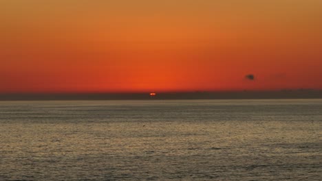 toma aérea del escenario dun sobre el horizonte del océano con un cielo naranja brillante