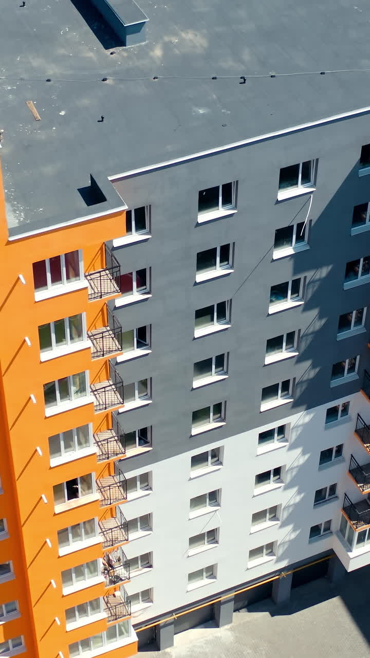 Apartment buildings with colorful walls. Modern residential apartments. Newly built block of flats for city residents. View from above. Vertical video