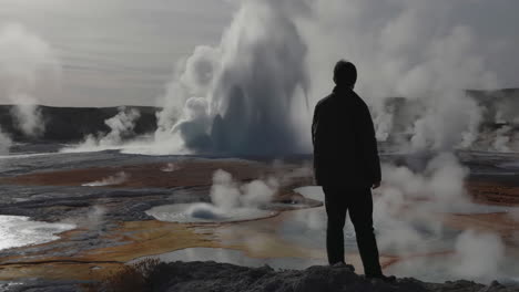 man standing near geothermal area with geysers