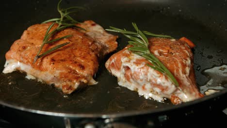 salmón sockeye cocinado en sartén caliente con condimento de romero