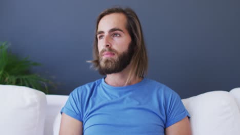 caucasian man using smartphone while sitting on the couch at home