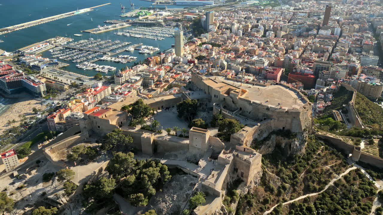 Aerial drone view of the Santa Barbara Castle on the coast of Alicante, Spain with the city and the sea on the background