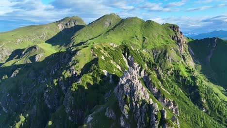 straight drone shot pushing in towards the green, rolling hills of the dolomites in italy on a sunny summer day