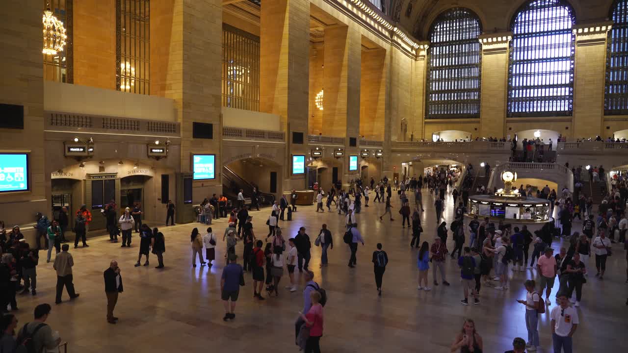 People walking along the elevated pedestrian walkway, overlooking the Main Concourse of Grand Central Terminal in New York