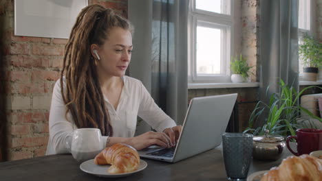 female freelancer having video chat during breakfast