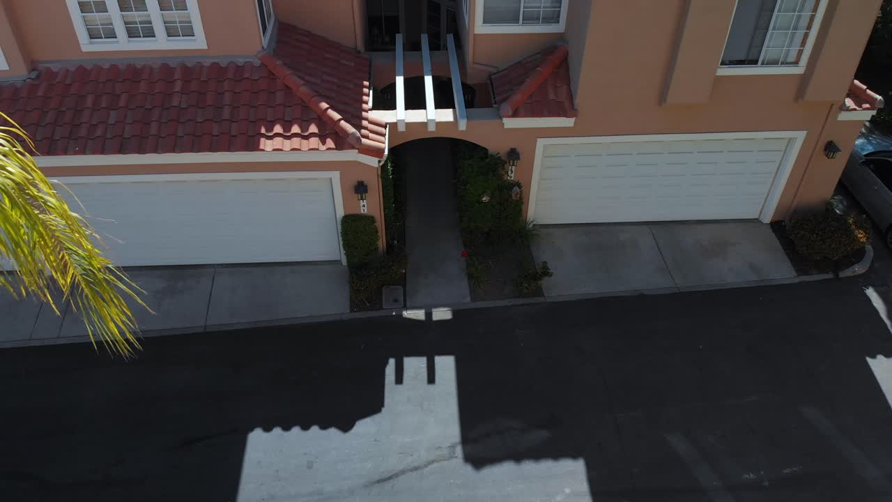 panorámica aérea decente hacia la entrada de un condominio