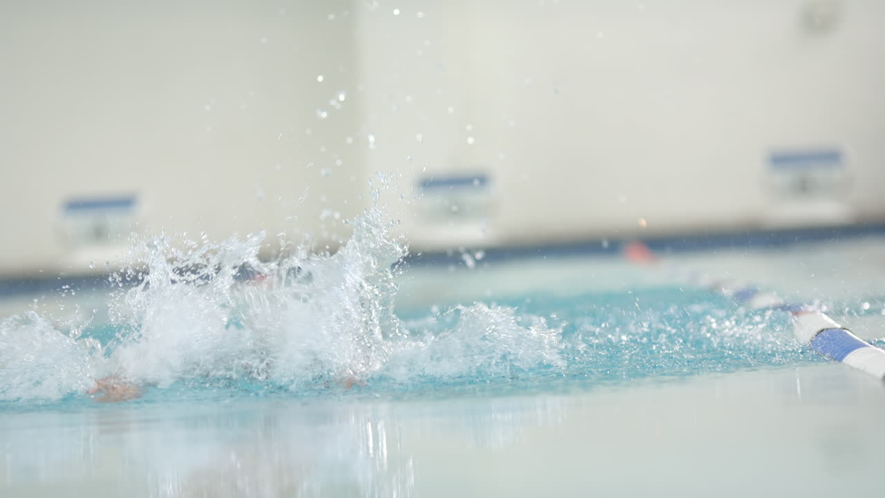 Swimming freestyle in pool, athlete creating splashes, copy space