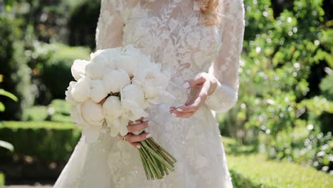 a bride holds wedding flowers bouquet in garden