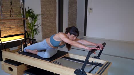 Woman-stretching-legs-on-pilates-reformer