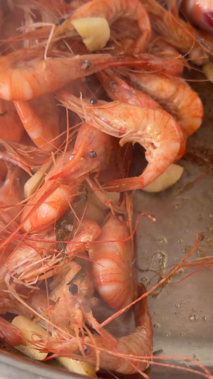 Gamberi e aglio sfrigolanti mescolati in una padella calda
