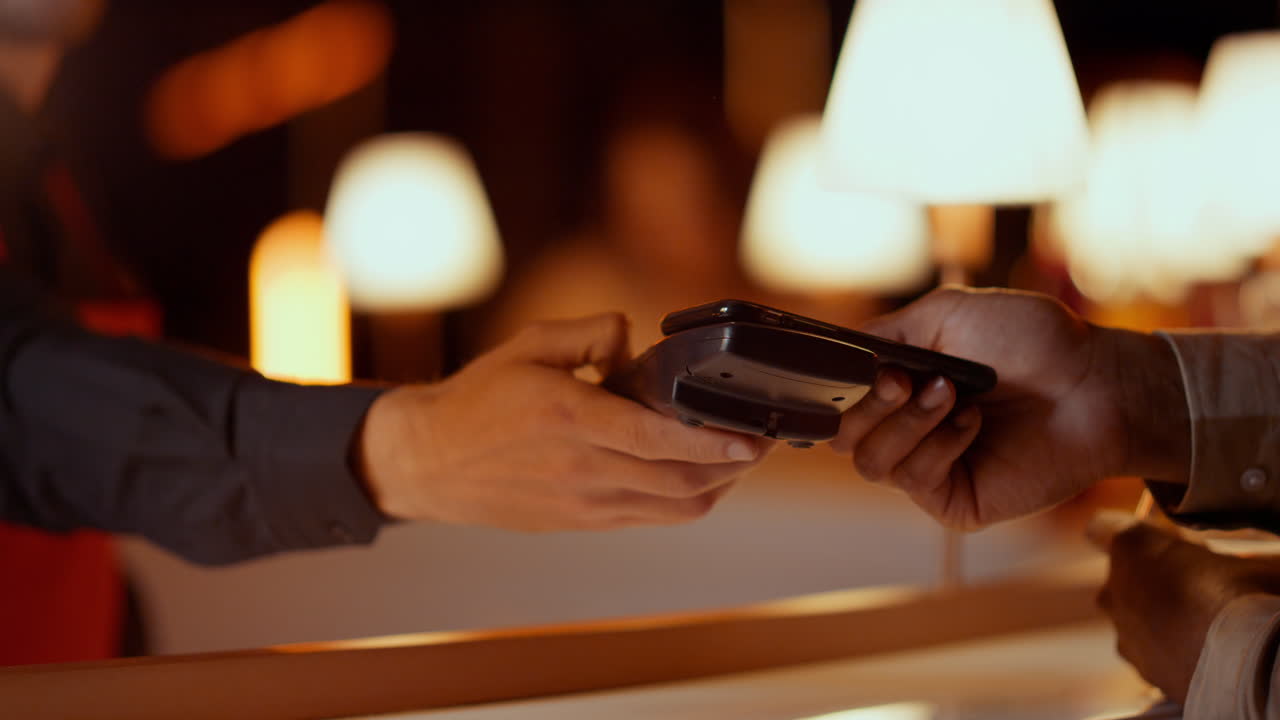 Waiter hand giving man bank terminal in bar. Guy making contactless payment