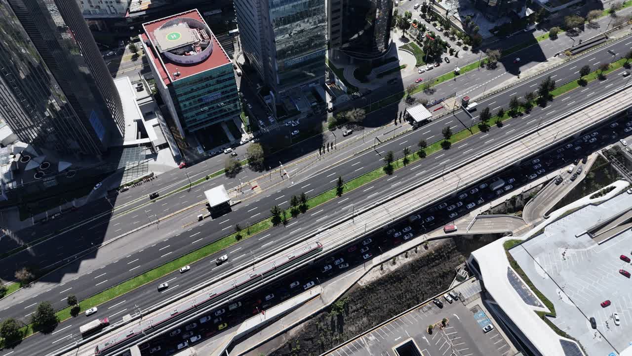 Drone footage of departing interurban train in Santa Fe, CDMX
