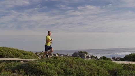 Kaukasischer-Mann-Genießt-Seine-Freizeit-Auf-Dem-Seeweg-Auf-Dem-Laufweg-An-Einem-Sonnigen-Tag