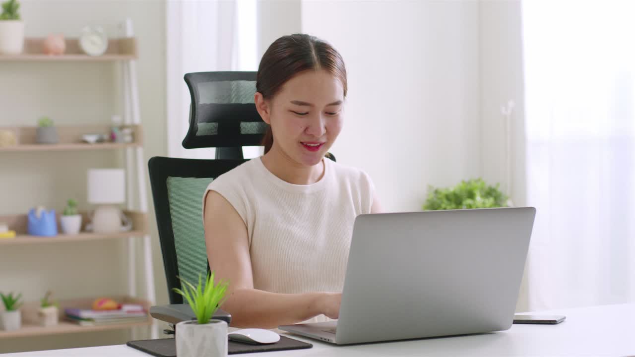 Young Asian woman working, shopping online,  with laptop computer at home